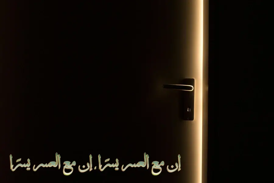 مقبض باب معدني مغلق يرمز إلى التحديات، مع بصيص ضوء يوحي بالأمل خلف الباب.
