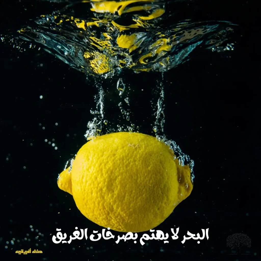ليمونة تسقط في الماء مع قطرات متناثرة.
