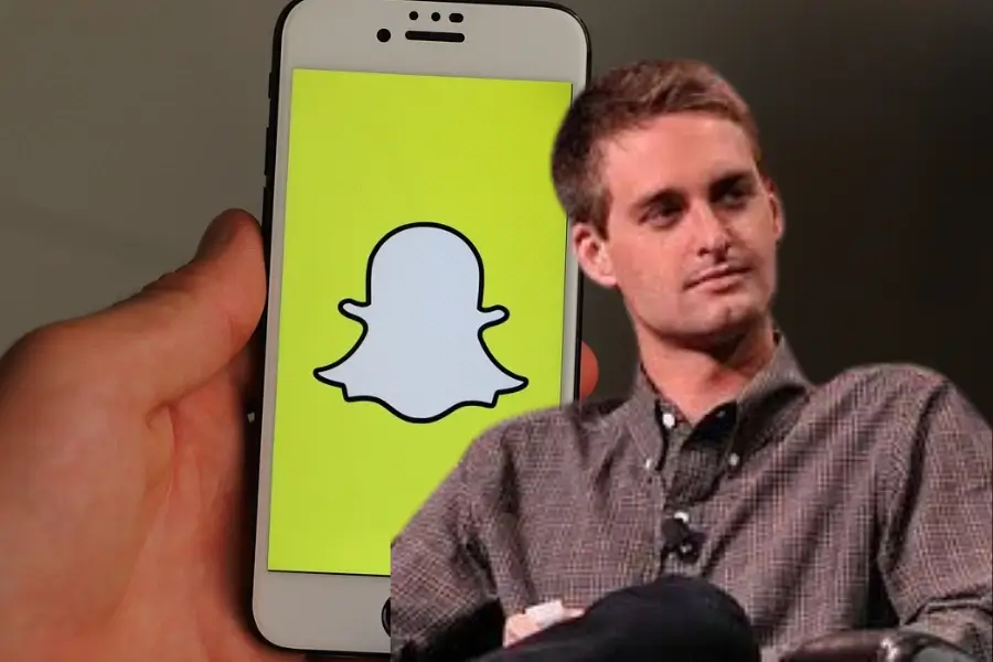 صورة إيفان شبيغل مبتكر تطبيق سناب شات، وخلفه شاشة هاتف تعرض شعار سناب شات.