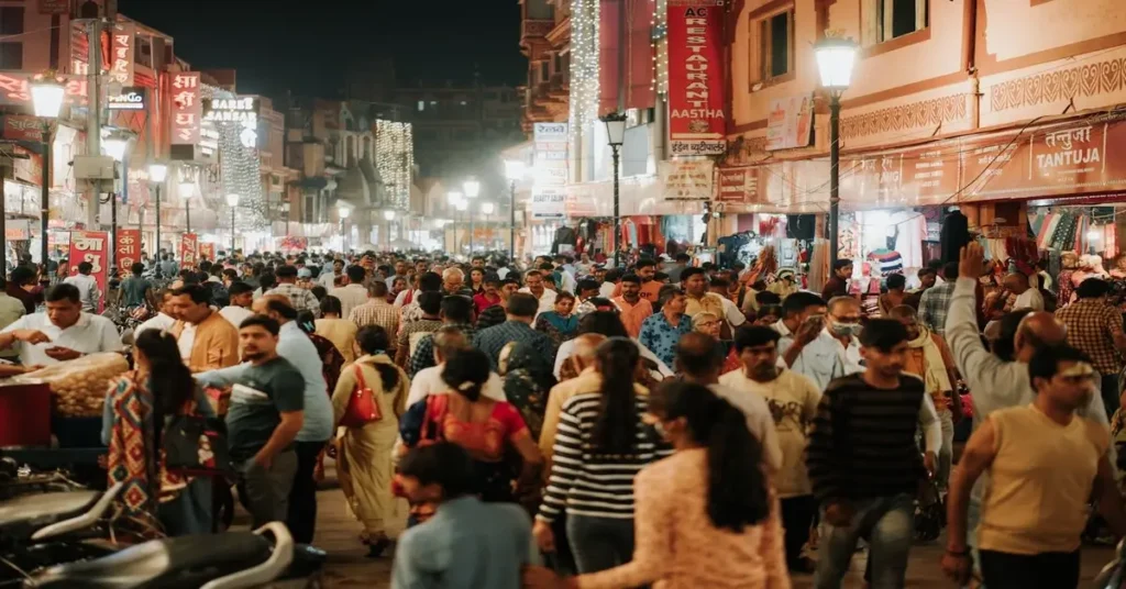 صورة لمشهد سوق شعبي مزدحم ليلاً في مدينة آسيوية، يظهر فيه الكثير من الناس والأضواء واللافتات، يرمز إلى "ضجة السوق" أو الفوضى والازدحام.